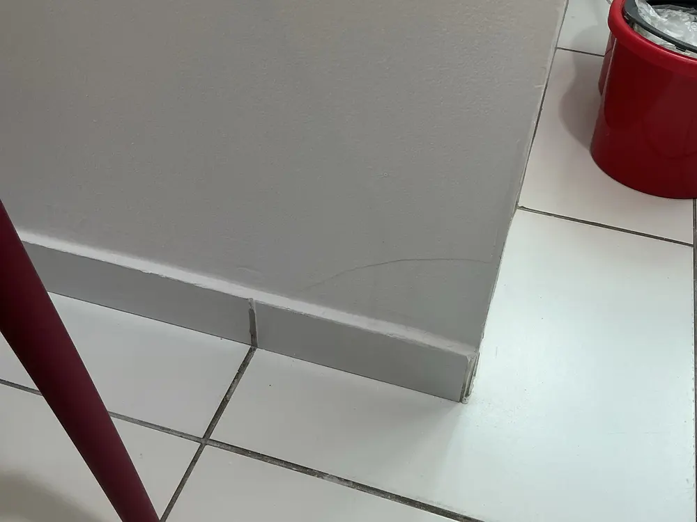 Fissura na parede junto ao rodapé, registrada em vistoria